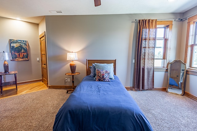 bedroom with multiple windows, ceiling fan, and light hardwood / wood-style flooring