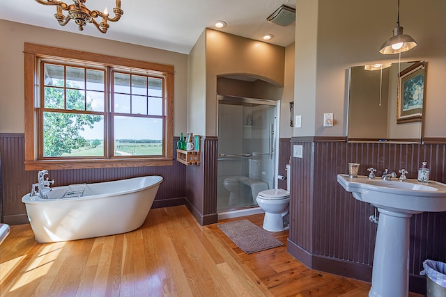 full bathroom with toilet, wood-type flooring, sink, wooden walls, and shower with separate bathtub