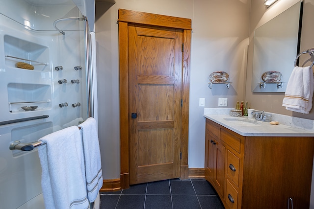 bathroom featuring walk in shower, vanity, and tile patterned floors