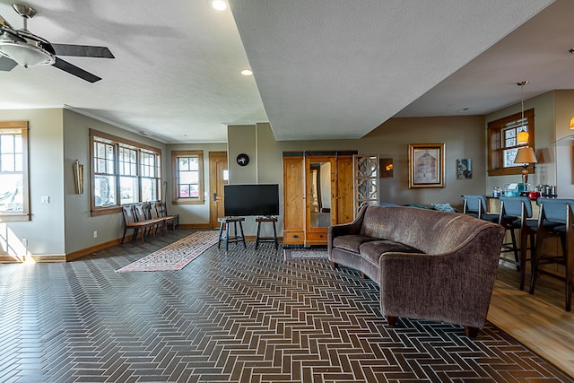 living room with ceiling fan and a textured ceiling