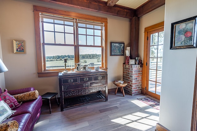 sitting room featuring beam ceiling and light hardwood / wood-style flooring