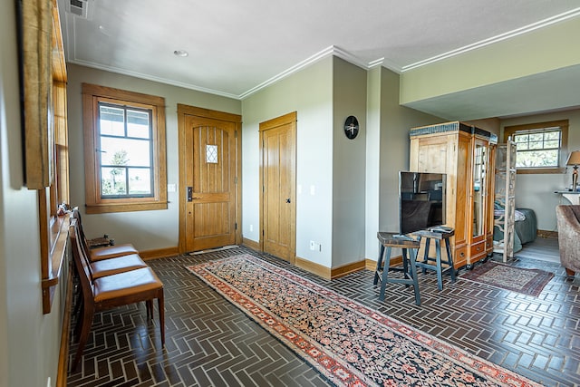 entrance foyer featuring ornamental molding and plenty of natural light