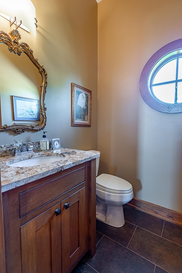 bathroom featuring tile patterned flooring, vanity, and toilet