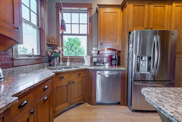 kitchen with light hardwood / wood-style flooring, stainless steel appliances, sink, and a healthy amount of sunlight