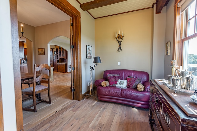 living room featuring beamed ceiling and light hardwood / wood-style floors