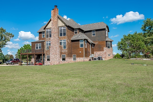 back of property with central AC unit and a lawn