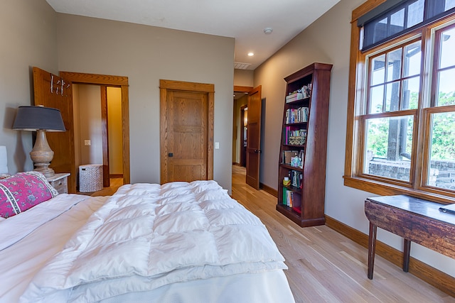 bedroom featuring multiple windows and light hardwood / wood-style floors