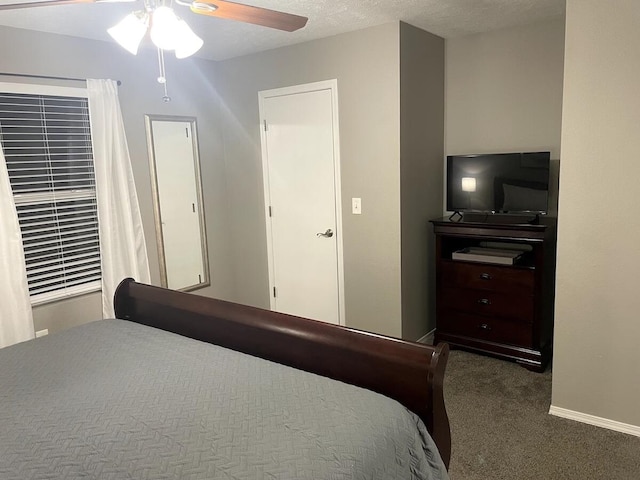 bedroom featuring ceiling fan, a textured ceiling, and dark colored carpet