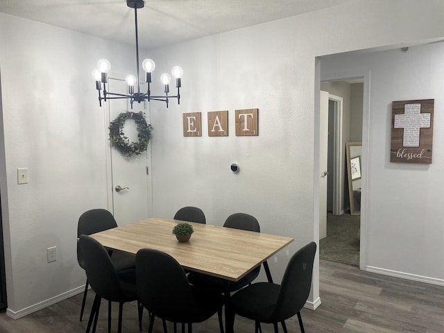 dining area featuring a textured ceiling, a notable chandelier, and dark hardwood / wood-style flooring