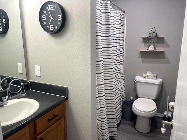 bathroom with hardwood / wood-style floors, vanity, toilet, and a shower with curtain