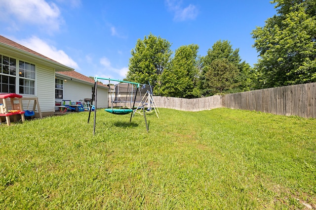 view of yard featuring a playground and a trampoline