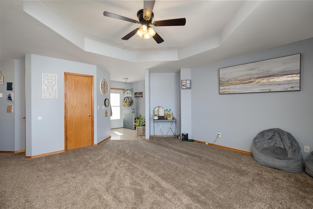 unfurnished room featuring carpet, a raised ceiling, and ceiling fan