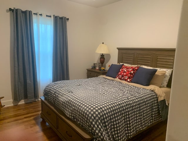 bedroom with dark hardwood / wood-style flooring