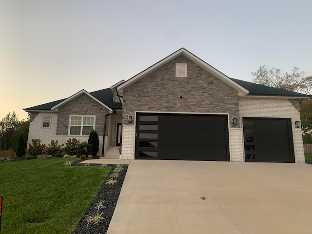 view of front of house with a garage and a yard