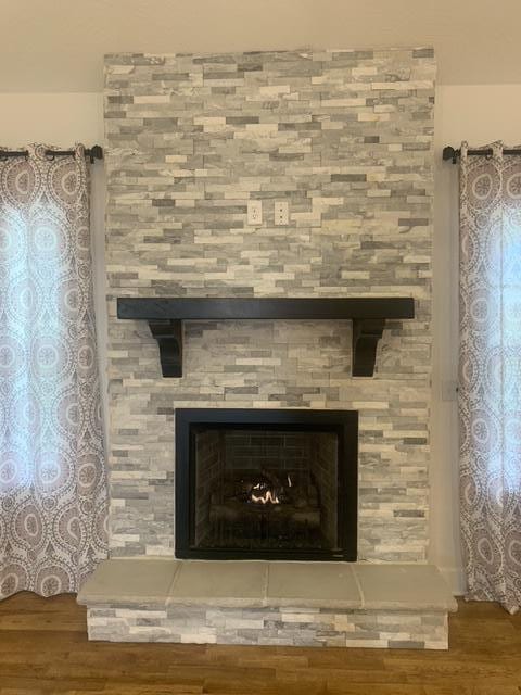 room details featuring hardwood / wood-style floors and a stone fireplace