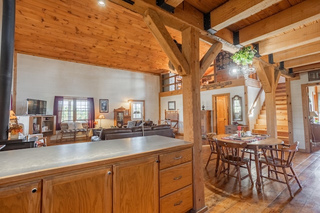 kitchen with light wood-type flooring, wood ceiling, a towering ceiling, and beam ceiling