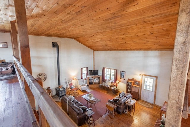 unfurnished living room with hardwood / wood-style flooring, wood ceiling, vaulted ceiling, and a wood stove