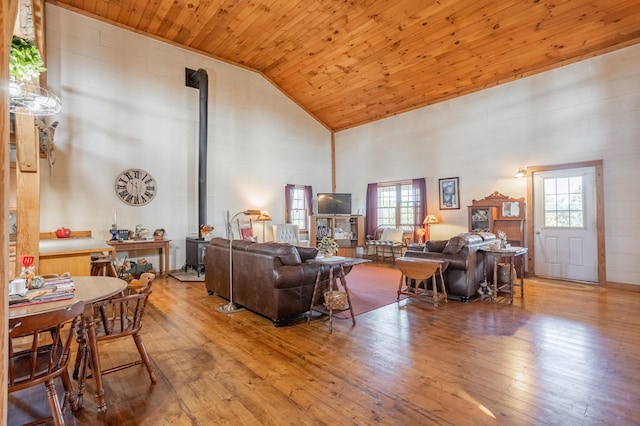 living room with a wood stove, light wood-type flooring, high vaulted ceiling, and wood ceiling