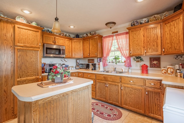 kitchen featuring light tile patterned flooring, sink, decorative light fixtures, stainless steel appliances, and crown molding