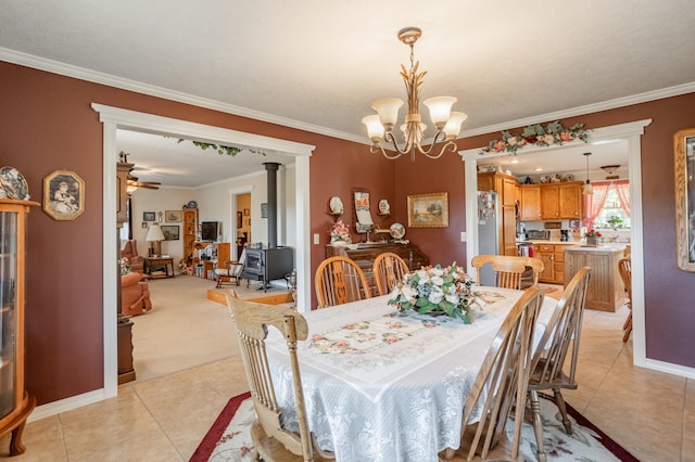 tiled dining space featuring ceiling fan with notable chandelier, crown molding, and a wood stove