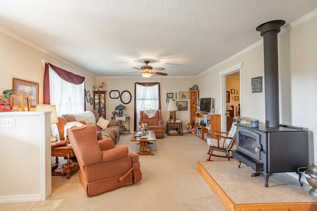 carpeted living room with ceiling fan, a textured ceiling, crown molding, and a wood stove