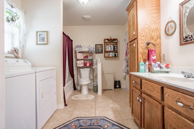 full bathroom featuring vanity, tile patterned floors, washing machine and clothes dryer, toilet, and a textured ceiling