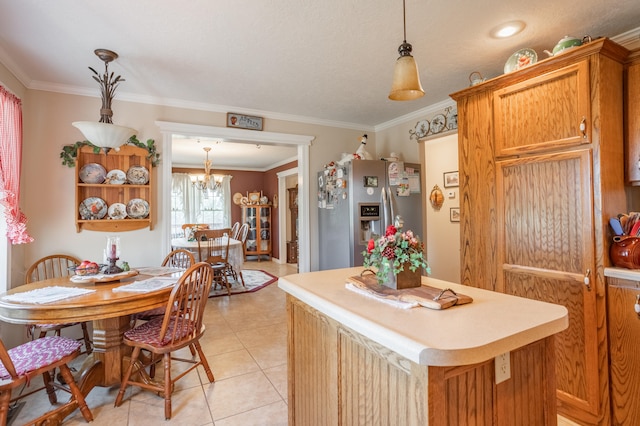 kitchen with hanging light fixtures, ornamental molding, stainless steel fridge, and a center island