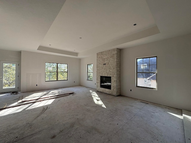 unfurnished living room featuring a fireplace and a raised ceiling