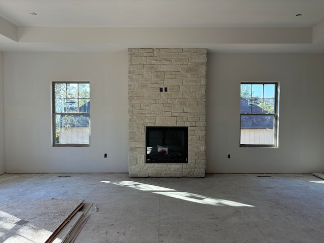 unfurnished living room with a fireplace and a wealth of natural light