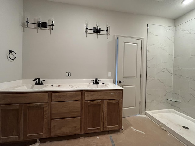 bathroom featuring tiled shower and vanity