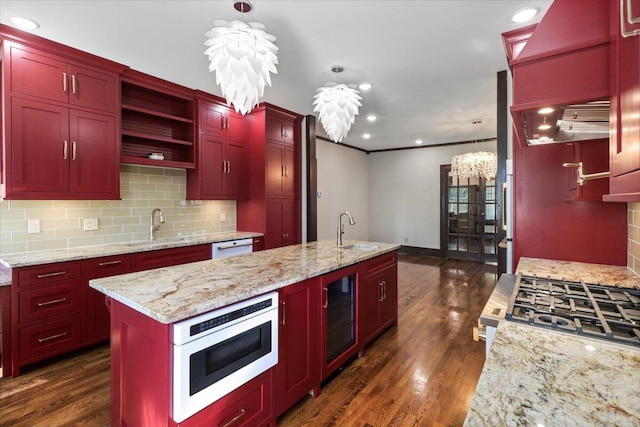 kitchen with dark hardwood / wood-style flooring, wine cooler, sink, hanging light fixtures, and an island with sink