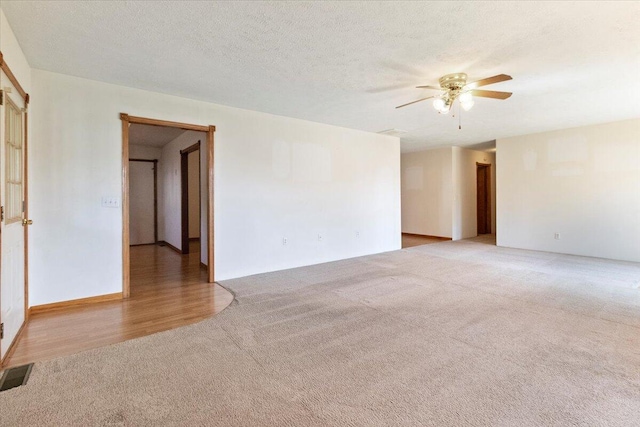 empty room with ceiling fan, a textured ceiling, and light wood-type flooring