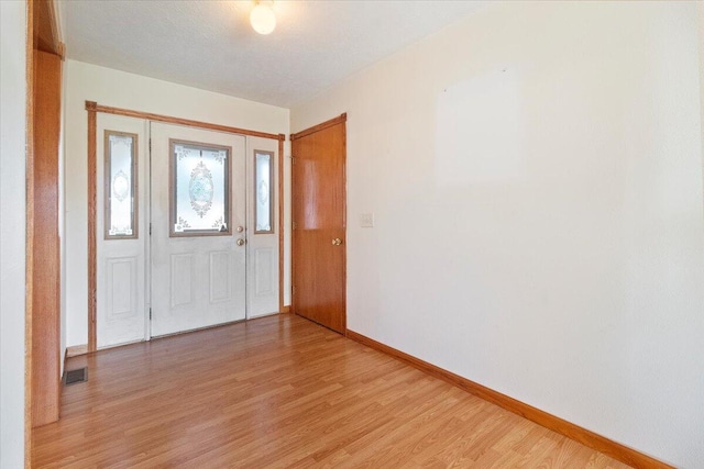 foyer entrance featuring hardwood / wood-style flooring and a textured ceiling