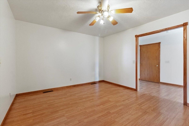 unfurnished room with ceiling fan, a textured ceiling, and light wood-type flooring