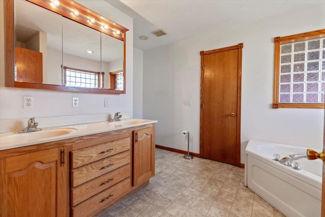 bathroom with vanity and a bath