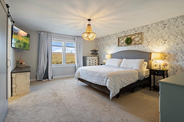 bedroom with a barn door, carpet floors, and an inviting chandelier