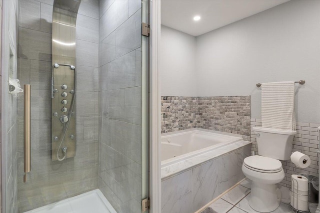 bathroom featuring tile walls, shower with separate bathtub, and toilet