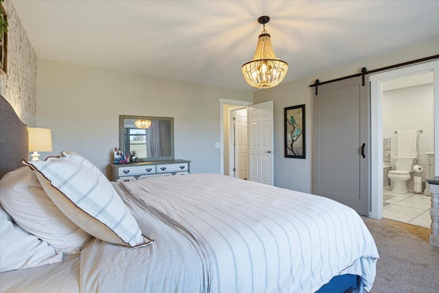 tiled bedroom featuring ensuite bath, a barn door, and a chandelier