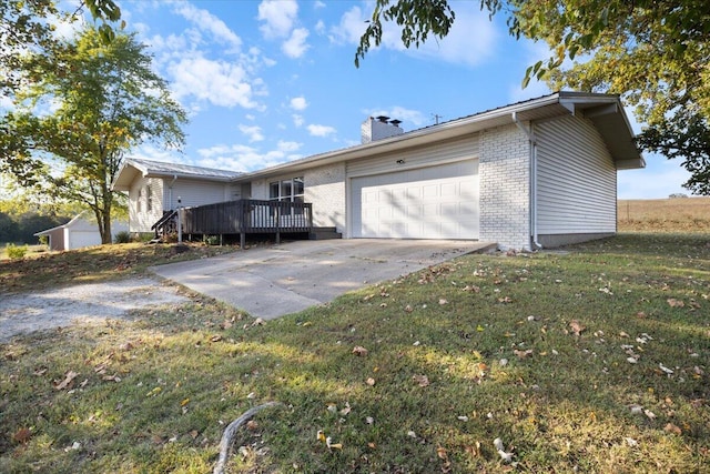 view of side of property with a garage, a wooden deck, and a lawn