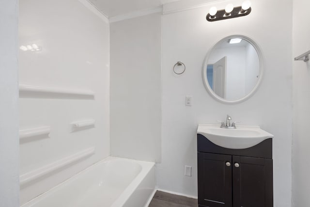 bathroom featuring ornamental molding, a bathing tub, vanity, and wood-type flooring