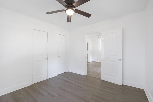 unfurnished bedroom featuring dark hardwood / wood-style floors and ceiling fan