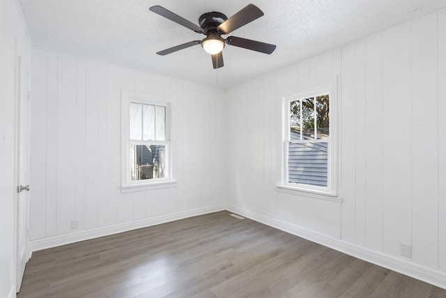 unfurnished room with ceiling fan, hardwood / wood-style flooring, and a textured ceiling