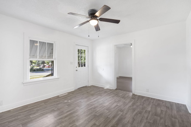 spare room with dark hardwood / wood-style flooring, a textured ceiling, and ceiling fan