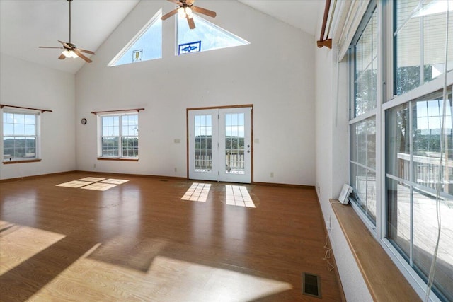 unfurnished living room with a high ceiling, french doors, and a wealth of natural light