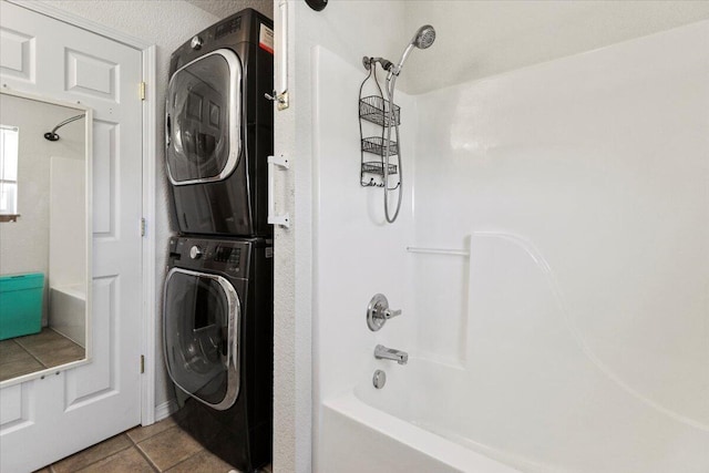 laundry room featuring stacked washer and clothes dryer and light tile patterned floors