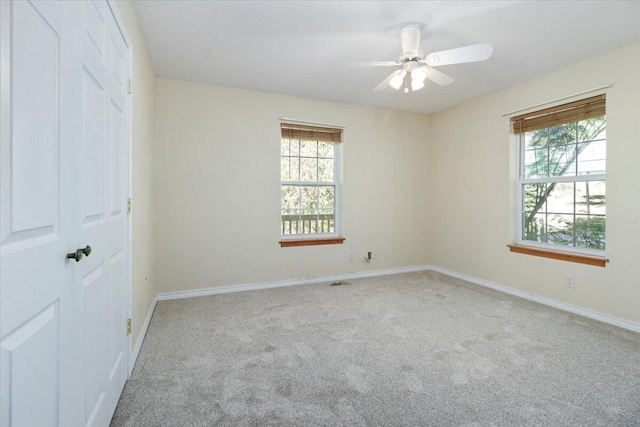 empty room with ceiling fan and light carpet