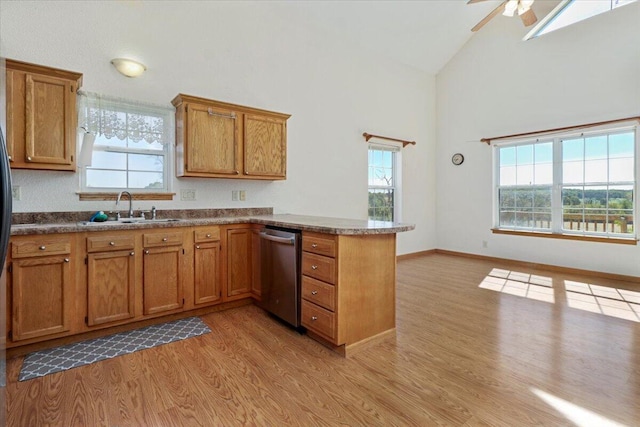 kitchen with dishwasher, kitchen peninsula, high vaulted ceiling, sink, and light hardwood / wood-style flooring