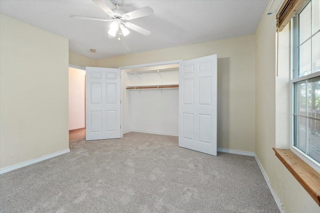 unfurnished bedroom featuring light carpet, a closet, and ceiling fan