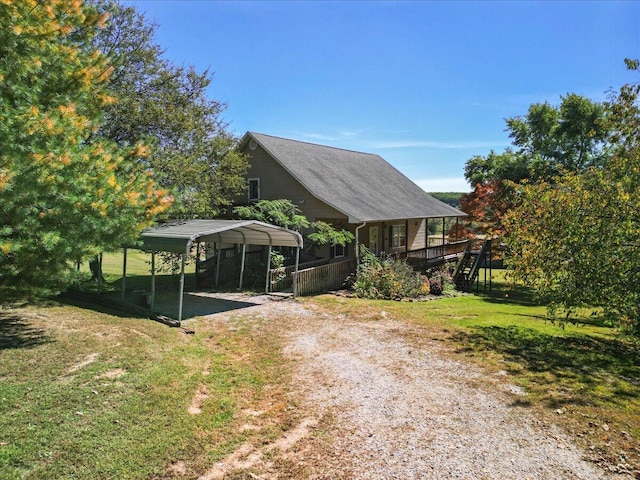 exterior space featuring a detached carport, driveway, stairs, and a lawn