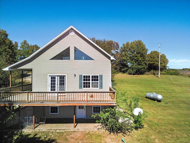 rear view of property with a lawn, a deck, and a patio